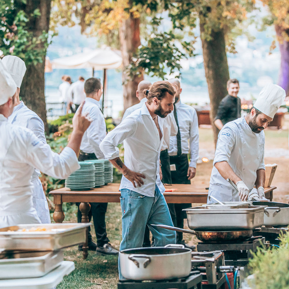 Camerieri e cuochi alle postazioni per cucinare
