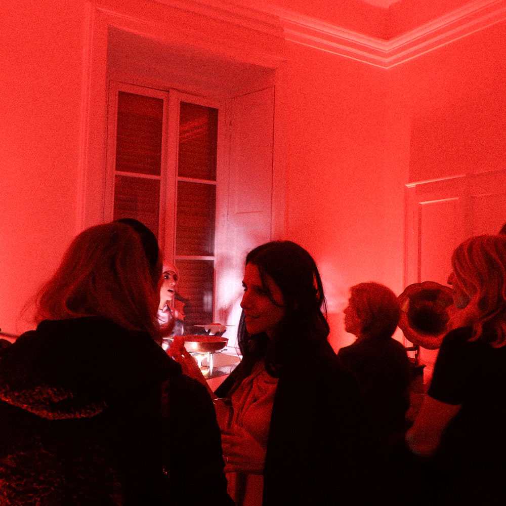 Persone in piedi all'evento con sfondo rosso
