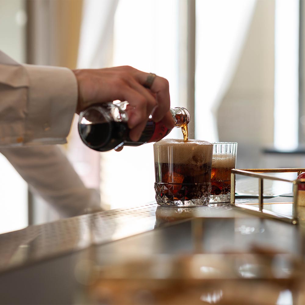 Cameriere che versa una Coca Cola