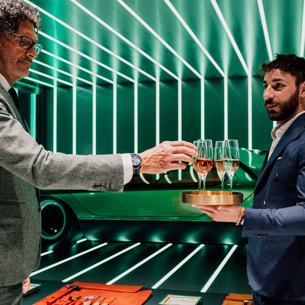 Uomo che porta un vassoio di flute di vino bianco