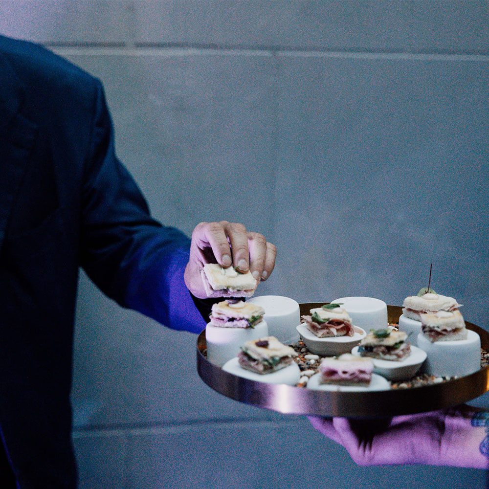 Cameriere che porta un vassoio di finger food
