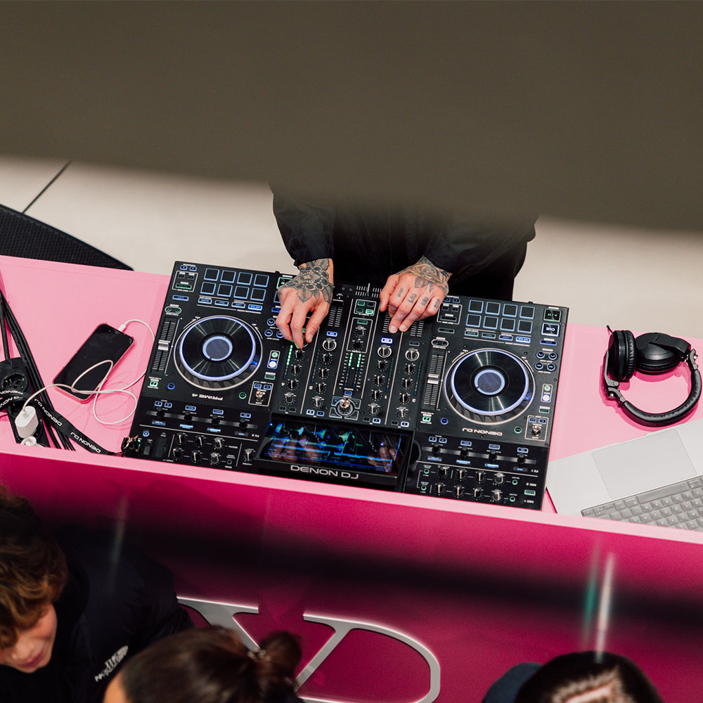 Console del dj con mani che sistemano i mixer