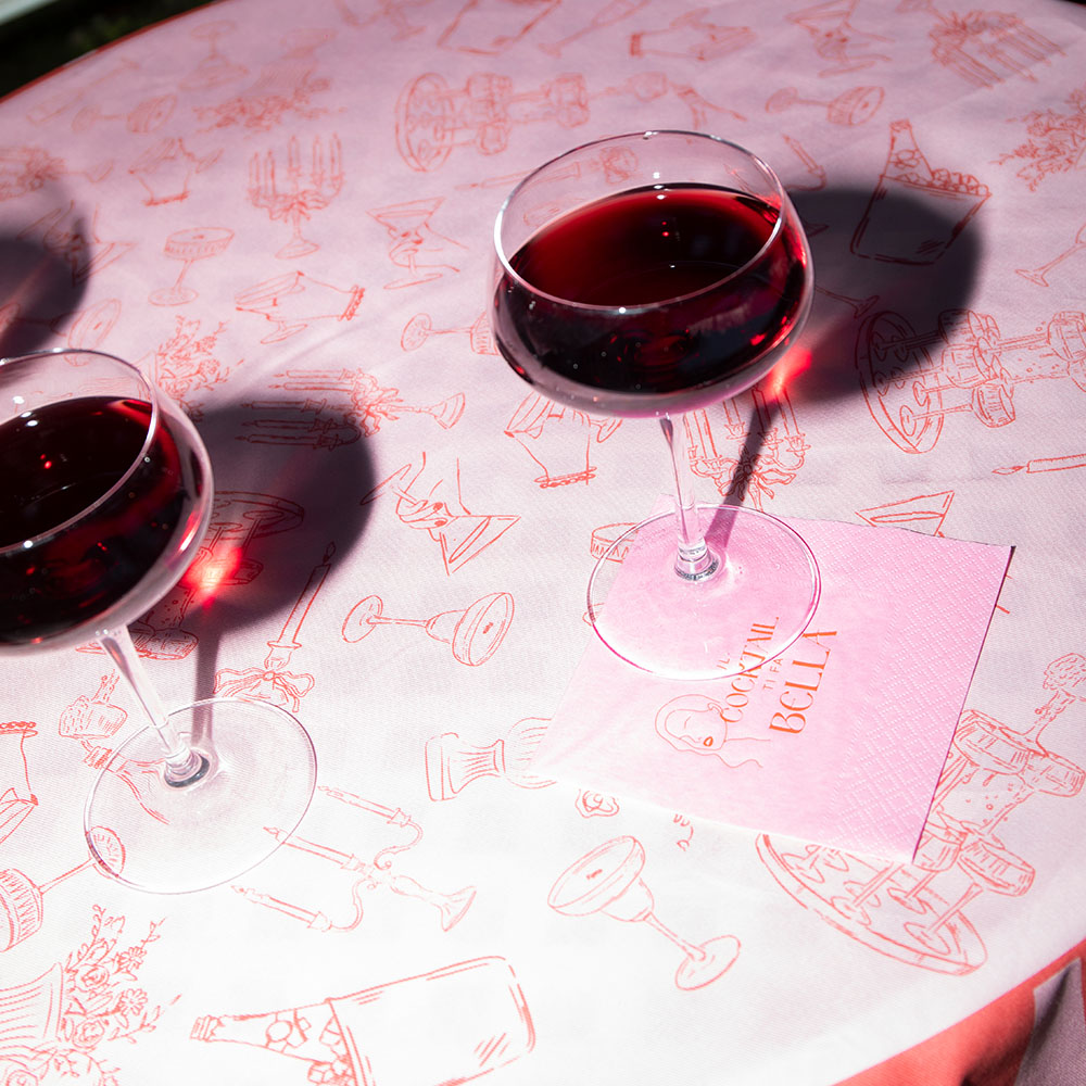Cocktail rossi sulla tovaglia ricamata rosa