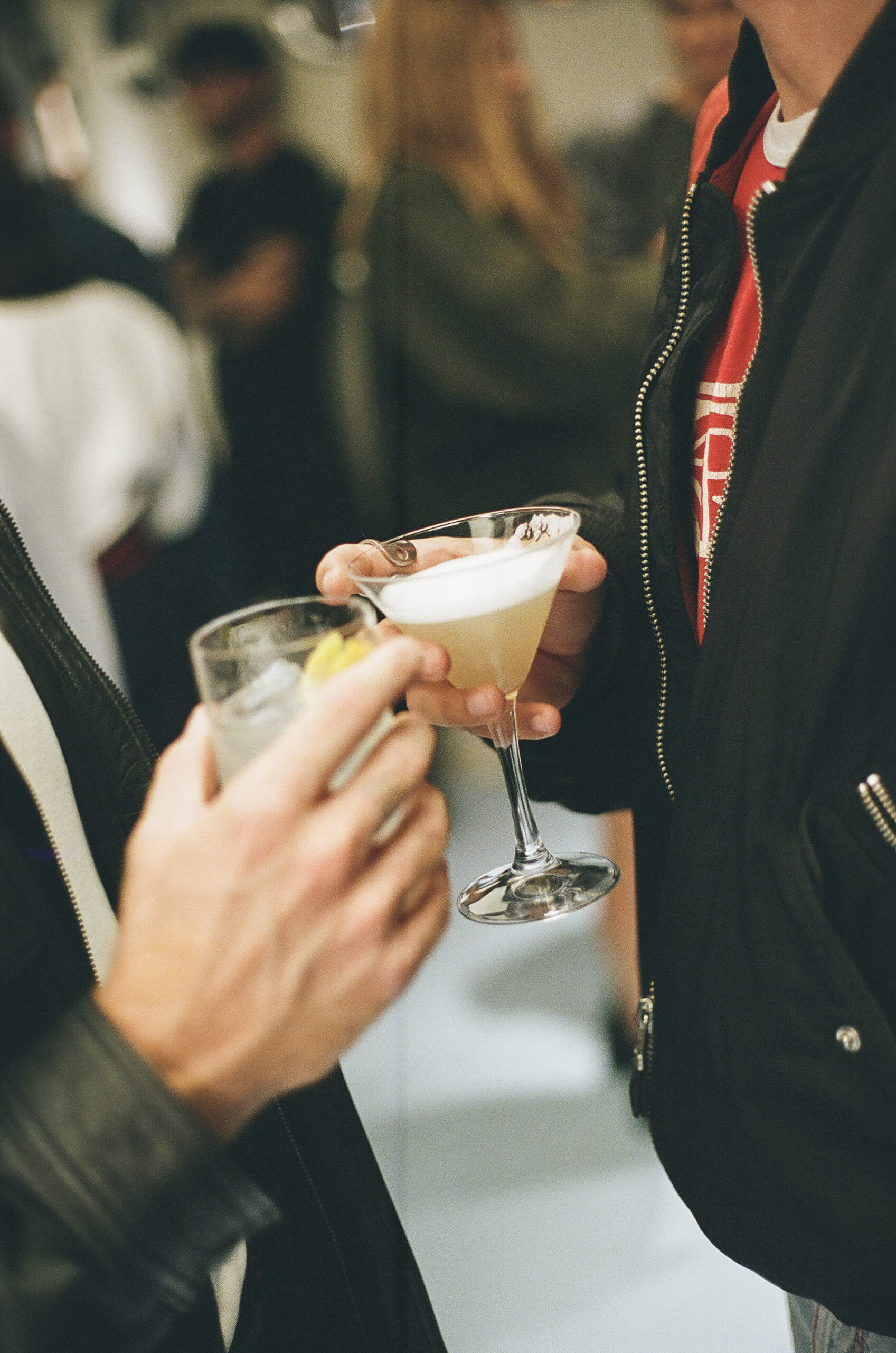Ragazzi che brindano con due cocktail tra le mani
