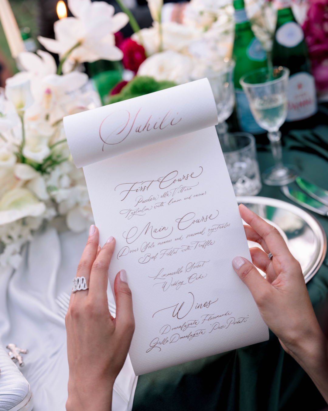 Menu scritto a mano e tenuto tra due mani femminili