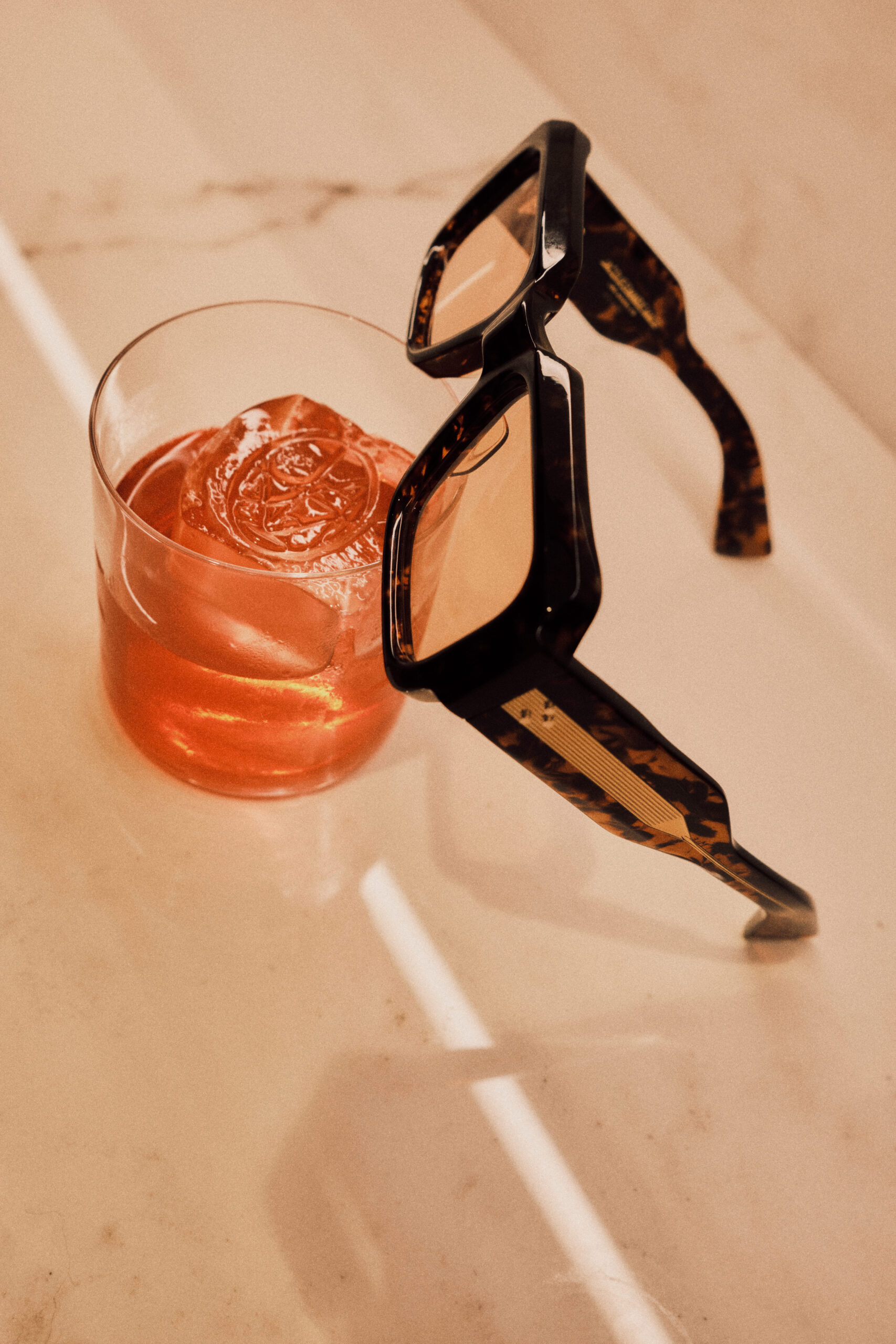 Bicchiere di cocktail rosso con occhiali da sole