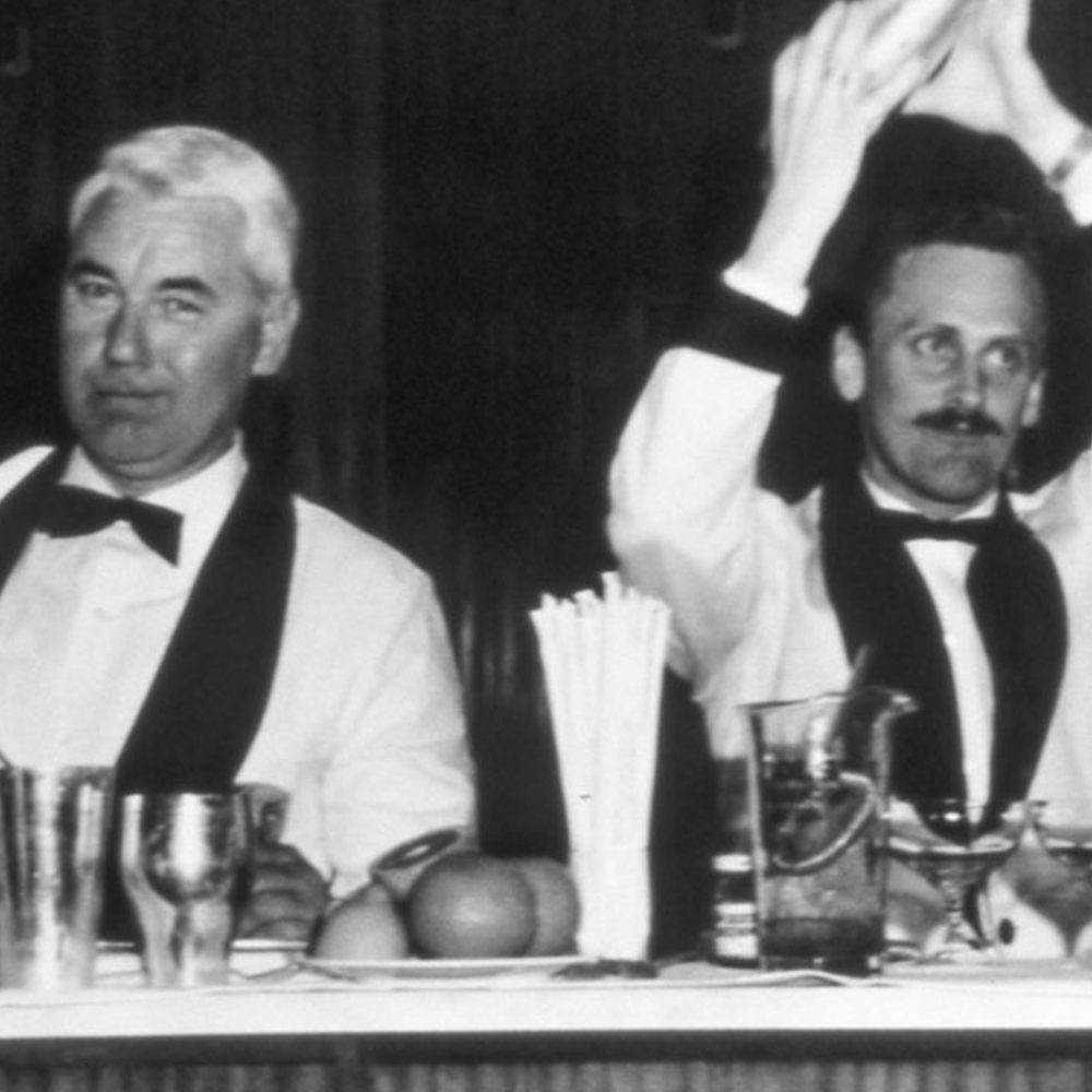 Camerieri in abito anni 60 dietro a un bancone